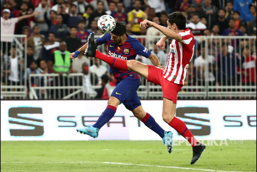 Luis Suarez menanduk bola dikawal Stefan Savic pada laga semifinal Piala Super Spanyol antara Barcelona melawan Atletico Madrid di King Abdullah Sport City Stadium, Jeddah, Jumat (10/1) dini hari.