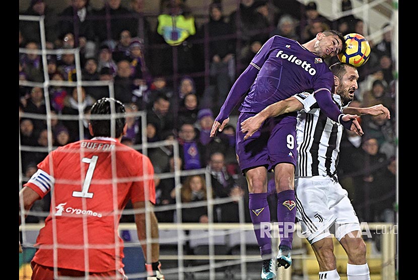 Giovanni Simeone (kiri)  dan bek Juventus Giorgio Chiellini (kanan) berebut bola pada laga Serie A ACF Fiorentina melawan Juventus FC di Stadium Artemio Franchi, Florence Itali, Sabtu (10/2) dini hari.