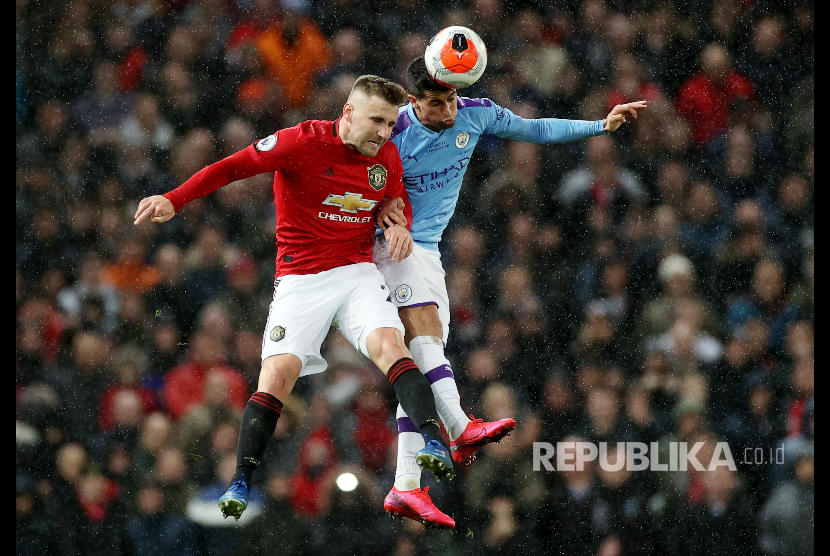 Luke Shaw dan Joao Cancelo berebut bola di udara pada laga derby antara Manchester United melawan Manchester City di Old Trafford, Senin (9/3) dini hari. 