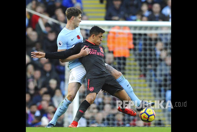  John Stones (kiri) mengganggu Alexis Sanchez pada pertandingan Liga Primer Inggris di Etihad Stadium, Manchester, Ahad (5/11).