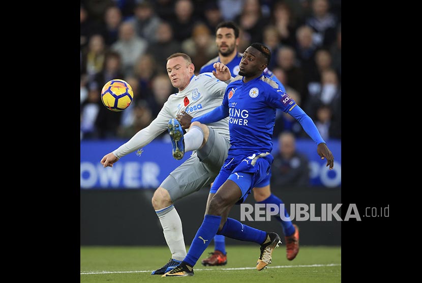 Pemain belakang Leicester City Wilfred Ndidi (kanan) berebut bola dengan striker Everton Wayne Rooney  pada pertandingan Liga Primer Inggris di Stadion King Power Stadium, Leicester, Inggris.