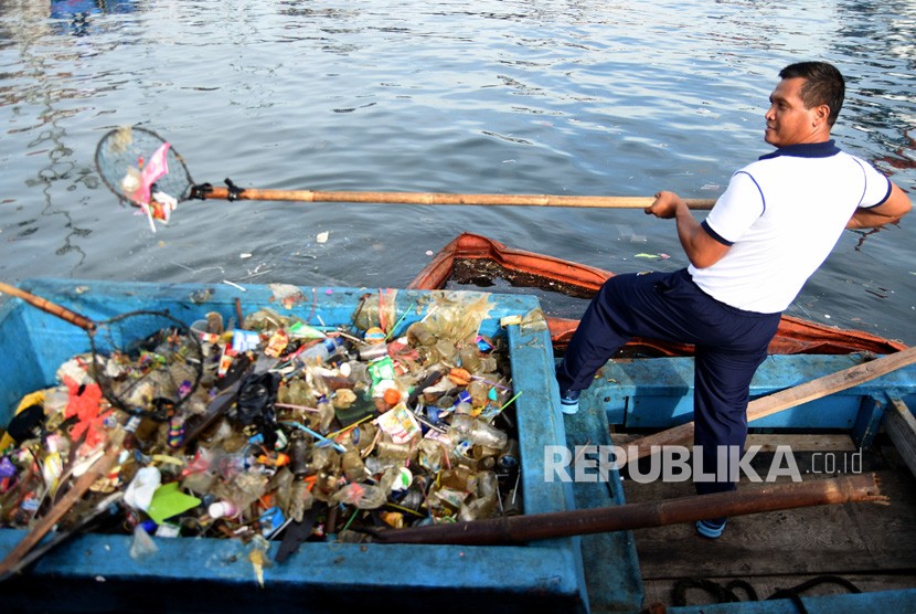 Pajurit TNI AL menjaring sampah di laut pada aksi bersih-bersih pantai dalam rangka gerakan Indonesia bersih di Dermaga Kolinlamil, Tanjung Priok, Jakarta Utara, Jumat (12/4/2019). 