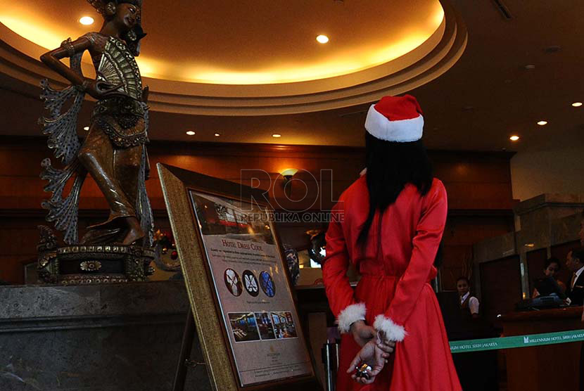 Pekerja mengenakan pakaian atribut natal pada salah satu Hotel di Jakarta, Senin (15/12)