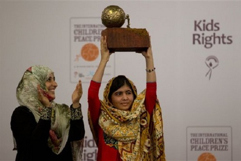 Pakistani teenager Malala Yousafzai, right, who was shot and injured by the Taliban for advocating girls' education, is awarded the International Children's Peace Prize 2013 by 2011 Nobel Peace Prize winner Tawakkol Karman of Yemen, left, during a ceremony