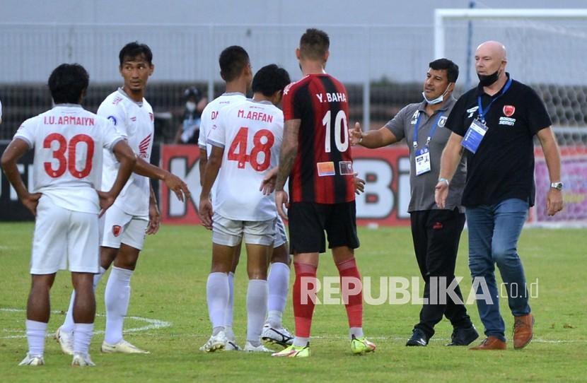 Palatih Persipura Jayapura Angel Alfredo Vera (kedua kanan) dan pelatih PSM Makassar Joop Gall (kanan) berbincang dengan sejumlah pemainnya usai pertandingan Liga 1 di Stadion Kompyang Sujana, Denpasar, Bali, Kamis (10/3/2022). Persipura Jayapura bermain imbang lawan PSM Makassar dengan skor 0-0.
