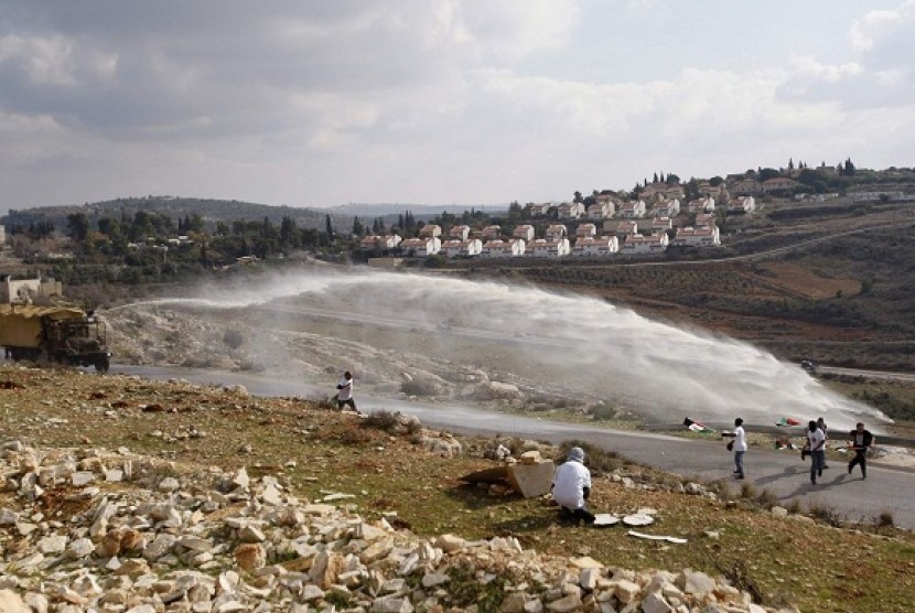 Palestinian and left-wing Israeli demonstrators run away as a foul smelling water cannon is fired by Israeli in the West Bank village of Nabi Saleh, near Ramallah, last year. Conflict of Israel and Palestine become the hottest spot in the world in modern e