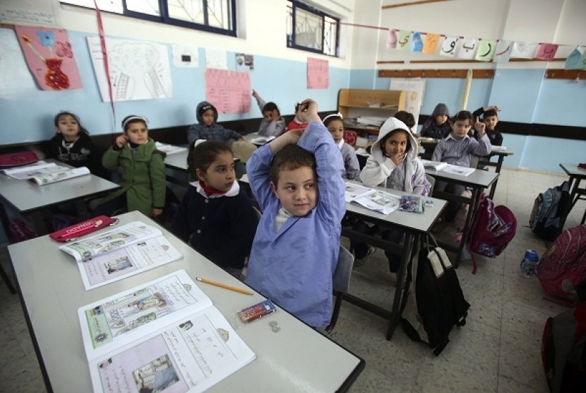 Palestinian first-graders sit with their schoolbooks during class in the West Bank city of Ramallah on Febryary 4. Palestine is under cash crisis and not able to pay the salary of its civil servants as Israel withold tax revenue taken from occupied territo