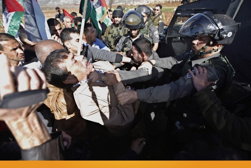 Palestinian minister Ziad Abu Ein (left) scuffles with an Israeli border policeman near the West Bank city of Ramallah December 10, 2014. 