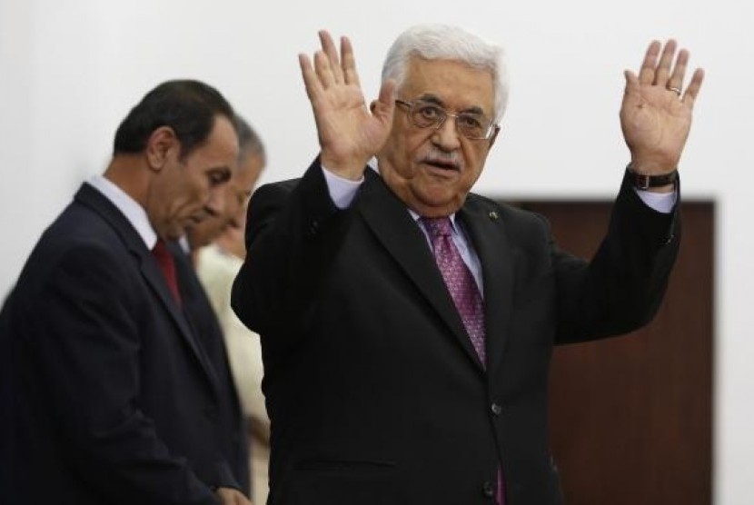 Palestinian President Mahmoud Abbas waves during a swearing-in ceremony of the unity government, in the West Bank city of Ramallah June 2, 2014.