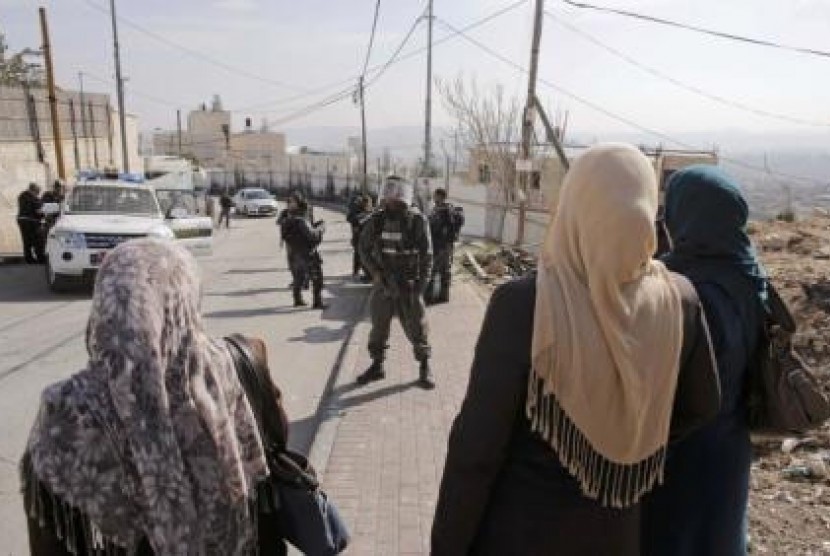Palestinian women stand in front of Israeli border police officers in the Jerusalem district of Jabal Mukaber November 18, 2014. 