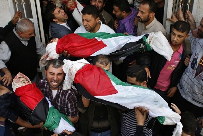 Palestinians carry the bodies of four siblings, who are children of the al-Dalo family, out of a hospital morgue during their funeral in Gaza City November 19, 2012. 