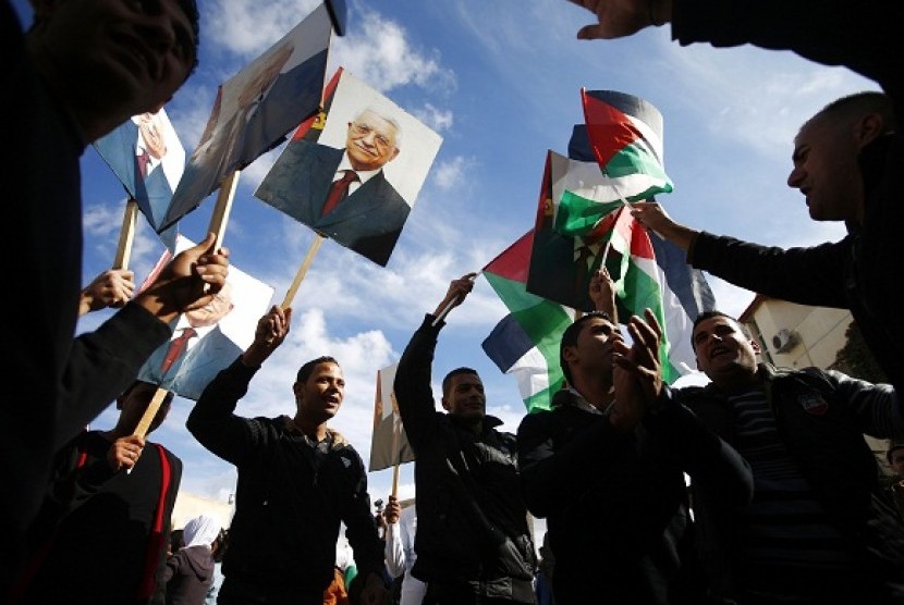 Palestinians hold placards depicting President Mahmoud Abbas during a rally in support of Abbas' efforts to secure a diplomatic upgrade at the United Nations, in the West Bank city of Ramallah November 25, 2012. Abbas will visit New York this week as the Palestinians seek an upgrade of its observer status at the United Nations from that of an 