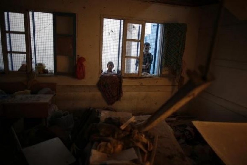 Palestinians look at a damaged classroom in a United Nation-run school sheltering Palestinians displaced by an Israeli ground offensive, that witnesses said was hit by Israeli shelling, in Jebalya refugee camp in the northern Gaza Strip July 30, 2014.