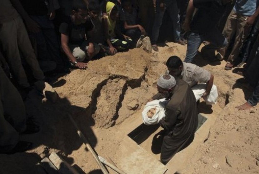 Palestinians prepare to bury the body of five-year-old boy Abdulrahman Khatab, who hospital officials said was killed in an Israeli air strike, on July 11, 2014.