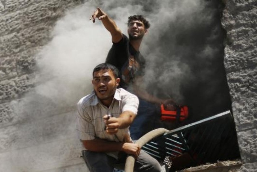 Palestinians react as they put out a fire in an apartment which witnesses said was hit by an Israeli air strike in Beit Lahiya in the northern Gaza Strip August 10, 2014.