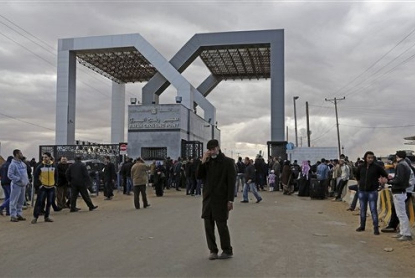 Palestinians wait to cross the border to the Egyptian side at Rafah crossing in the southern Gaza Strip, Sunday, Dec. 21, 2014. 
