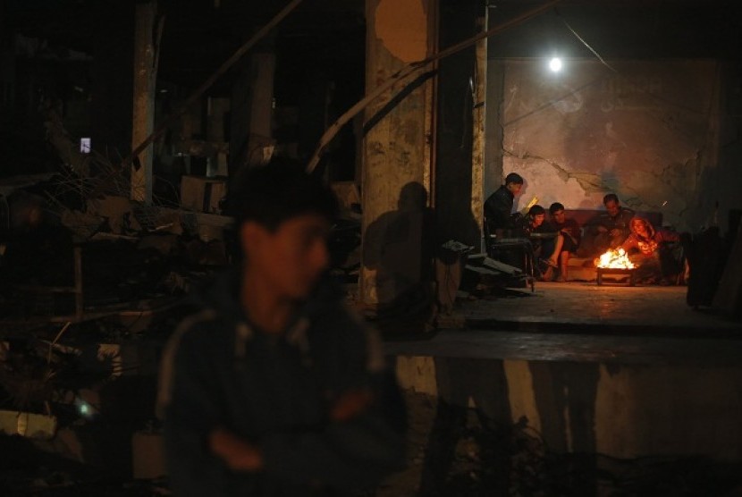 Palestinians warm themselves by a fire inside a house, which witnesses said was damaged in an Israeli air strike during an eight-day conflict, in the northern Gaza Strip December 20, 2012. (illustration)  