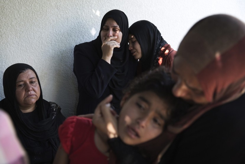 Palestinians weep after what medics said was an Israeli shell that hit a U.N-run school sheltering Palestinian refugees, at a hospital in Jabaliya in the northern Gaza Strip July 24, 2014. At least 15 people were killed and many wounded on Thursday when Is