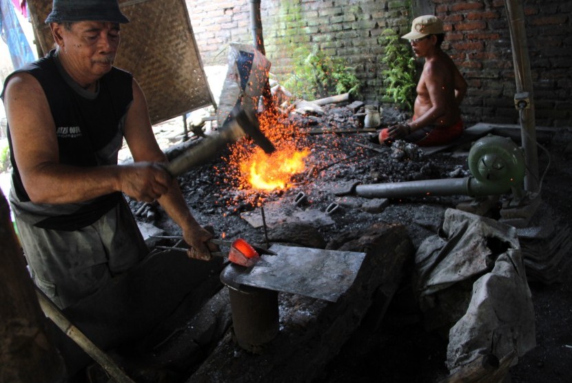Pande besi membuat cangkul secara tradisional di sentra kerajinan cangkul, Tulungagung, Jawa Timur, Rabu (2/11).