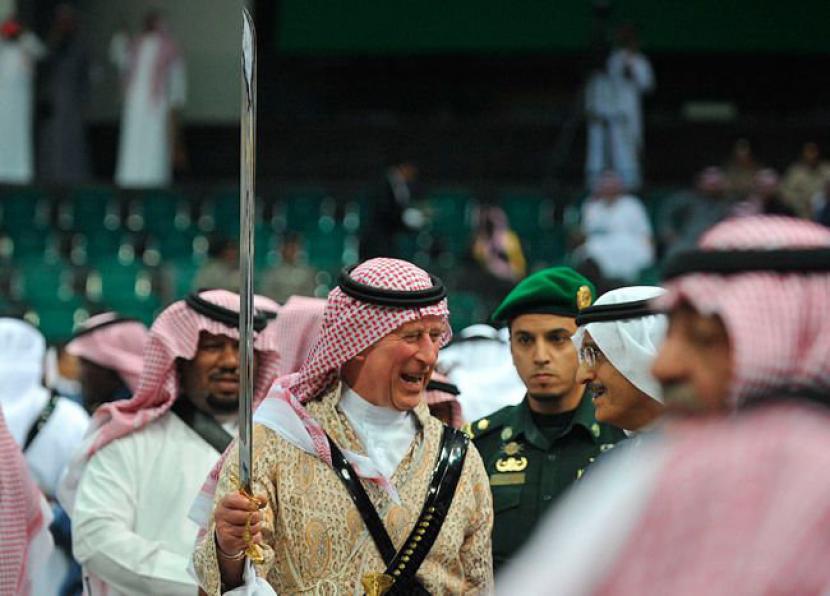 Pangeran Charles saat itu, berpartisipasi dalam tarian pedang atau ardah dengan mengenakan jubah tradisional Arab Saudi di festival budaya Janadriyah di Riyadh, Februari  2014. Penobatan Raja Charles, Keakrabannya dengan Dunia Arab dan Muslim