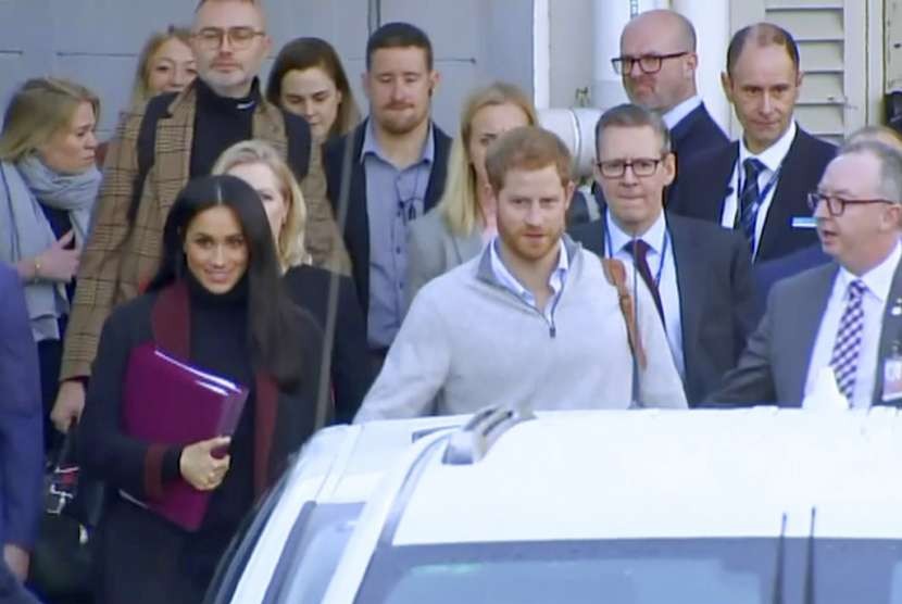 Pangeran Harry dan istrinya Meghan Markle saat tiba di Bandara Sydney, Australia, Senin (15/10).