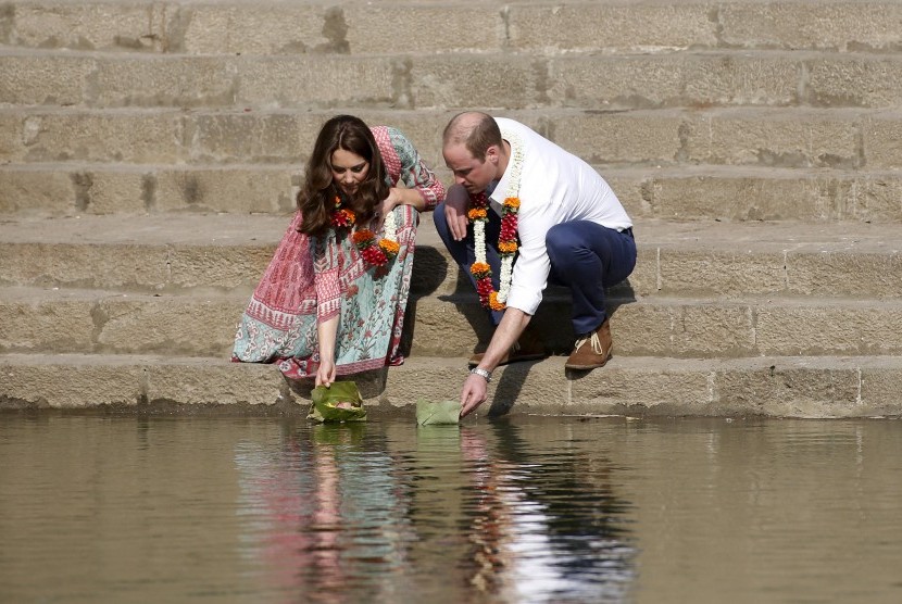 Pangeran William dan Kate Middleton saat meletakkan bunga untuk mengambang di Banganga Water Tank di Mumbai, Ahad (10/4).