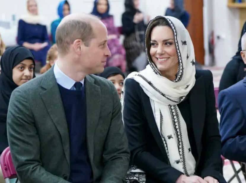 Pangeran William dan Kate Middleton saling berpandangan saat mengunjungi Muslim Center di London, Inggris, Kamis (9/3/2023). Middleton tampak menggunakan selendang putih keluaran jenama Pakistan, Elan, untuk menutupi kepalanya.