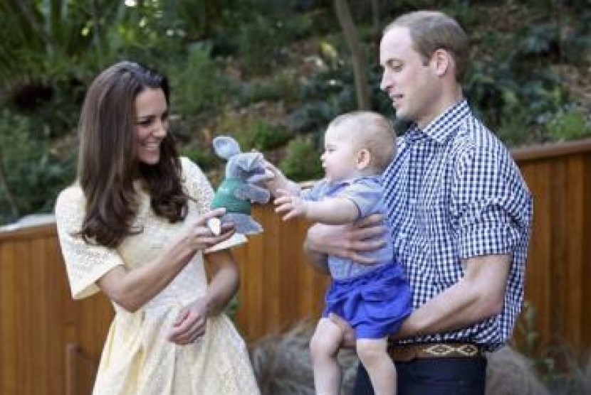 Pangeran William menggendong Pangeran George ketika istrinya, Catherine, memberikan boneka mainan dalam kunjungan mereka ke kebun binatang Taronga, Sydney, Ahad (20/4).