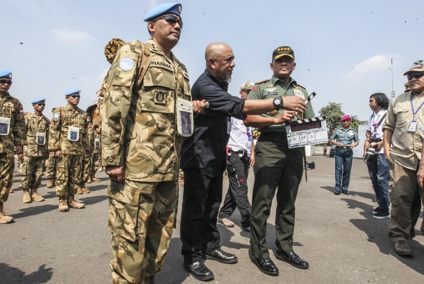 Panglima TNI Jenderal TNI Gatot Nurmantyo (kanan) membawa 'clapper board' sebagai tanda dimulainya syuting perdana film Garuda 23 di Bandara Halim Perdana Kusuma, Jakarta, Jumat (29/7). 