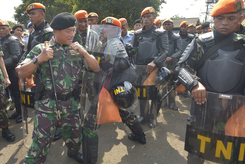 Panglima TNI Jenderal TNI Moeldoko (kiri) mencoba kesiapan seorang prajurit pengendali huru hara Pasukan Khas TNI AU ketika melakukan peninjauan di Halim Pedanakusuma, Jakarta, Rabu (16/7).   (Antara/Saptono)