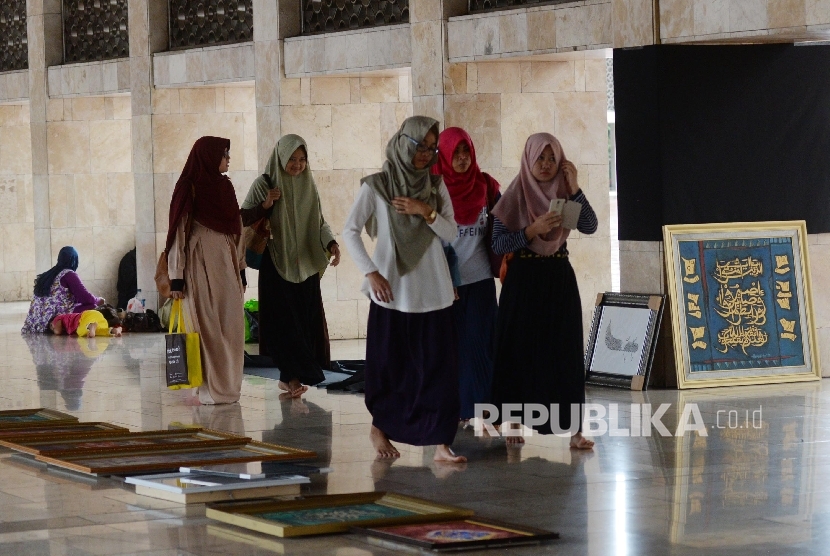 Panitia memasang kaligrafi untuk mempersiapkan pameran di Masjid Istiqlal, Jakarta, Ahad (19/2). 