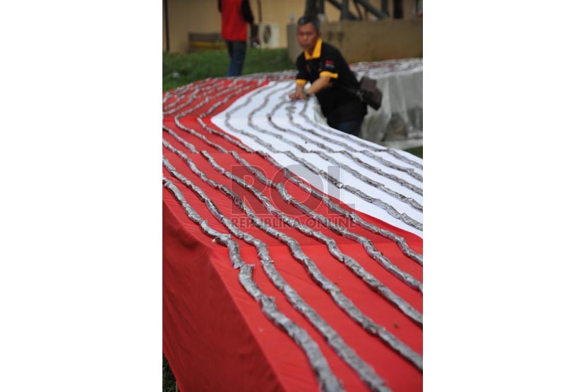 Panitia menata kembali instalasi jajaran dodol strawbery pada pemecahan rekor MURI dalam pembuatan dodol strawbery terpanjang pada festival strawbery di Taman Mini Indonesia Indah, Jakarta Timur, Jumat (22/8). (Republika/Rakhmawaty La'lang)
