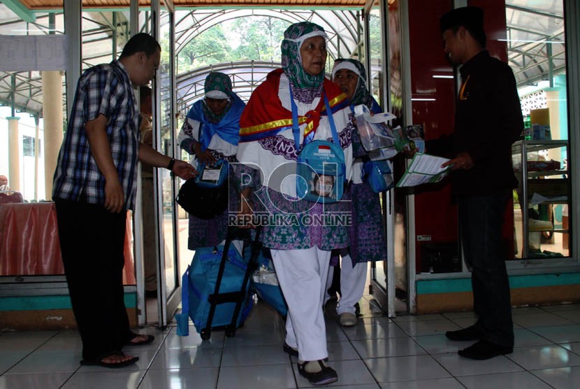 Panitia Pelaksana Ibadah Haji (PPIH) memeriksa kartu kamar calon jamaah haji kloter 20 asal Jakarta saat memasuki Asrama Haji Pondok Gede, Jakarta, Senin (23/9).