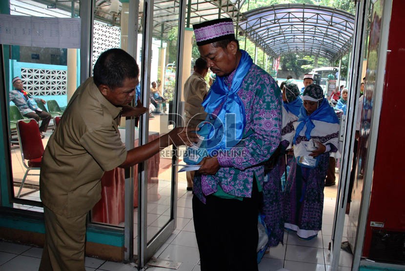 Panitia Pelaksana Ibadah Haji (PPIH) memeriksa kartu kamar calon jamaah haji kloter 20 asal Jakarta saat memasuki Asrama Haji Pondok Gede, Jakarta, Senin (23/9).