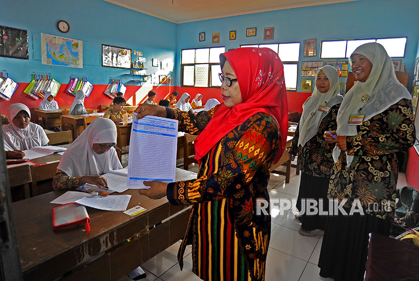 Panitia pengawasan membagikan lembar jawaban esai kepada peserta Ujian Nasional (UN) di SD Negeri 3 Ciceri, Serang, Banten, Kamis (3/5). 