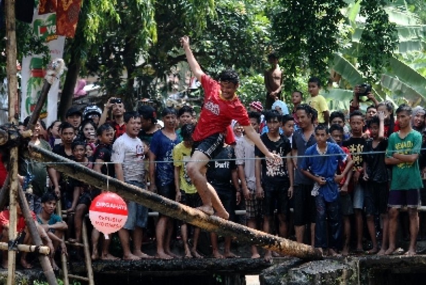 Panjat pinang di tengah sungai yang berlangsung di Kalimalang, Jakarta Timur
