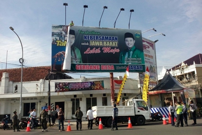 Panwaslu tengah mencopot billboard bergambar Wali Kota Tasikmalaya nonaktif Budi Budiman dan Bupati Tasikmalaya Uu Ruzhanul Ulum, Rabu (28/12). Pencopotan dilakukan karena melanggar aturan alat peraga kampanye.