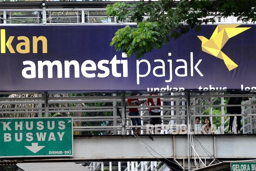 Papan iklan sosialisasi pengampunan pajak terpasang di Jl Sudirman, Jakarta.