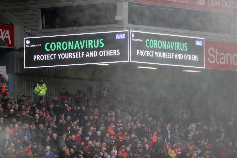 Papan informasi bertuliskan imbauan mengenai virus corona terlihat di dalam stadion saat pertandingan lanjutan liga Inggris antara Liverpool melawan Bournemouth, Sabtu (7/3).Inggris mengumumkan dana senilai 30 miliar poundsterling atau sekitar Rp 553,4 triliun untuk meringankan dampak ekonomi dari virus corona  