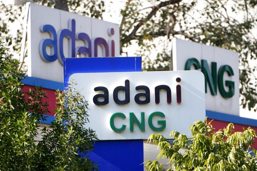 Papan nama SPBU Adani dipajang di outlet perusahaan di Ahmedabad, India, 2 Februari 2023 (ilustrasi). Grup Adani India telah memangkas separuh target pertumbuhan pendapatannya. Perusahaan itu pun berencana menurunkan belanja modal baru.