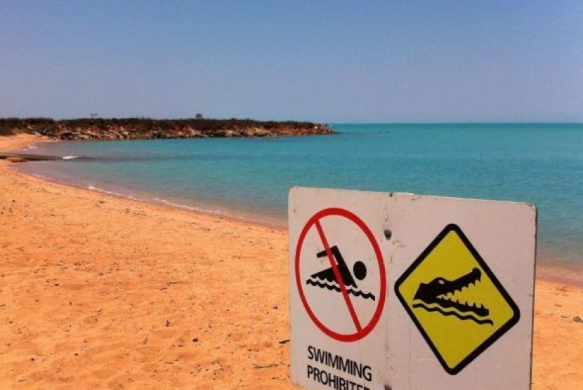 Papan peringatan bagi warga yang berenang dan nelayan tentang bahaya buaya di kota pantai Broome.