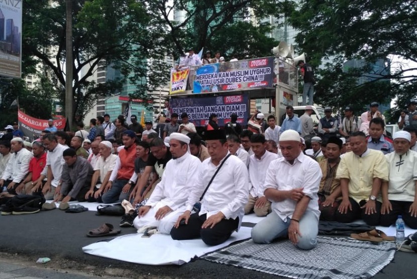 Para aksi bela muslim Uighur melakukan shalat ashar di depan gedung kedutaan besar RRC, Jakarta Selatan, Jumat ( 21/12).