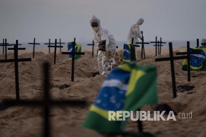  Para aktivis  dari LSM Rio de Paz dengan mengenakan kostum  menggali kuburan simbolis dalam memprotes penanganan pemerintah terhadap pandemi COVID-19 di pantai Copacabana, di Rio de Janeiro, Brasil, Kamis (11/6). 