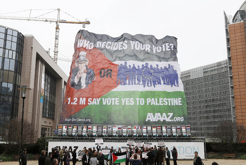 Para aktivis membentangkan bendera Palestina raksasa dalam aksi mendukung negara Palestina merdeka di luar Gedung Dewan Uni Eropa di Brussels, Senin (19/11). (Reuters/Francois Lenoir)