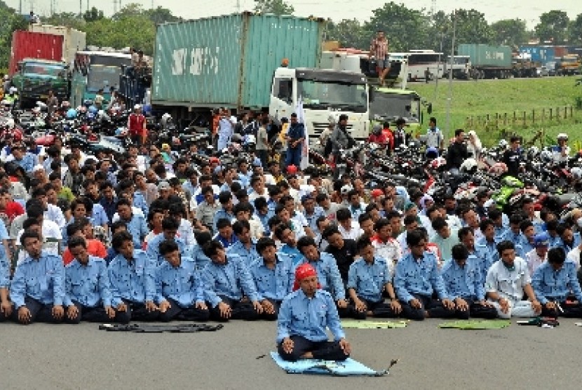 Para buruh melakukan Shalat Jumat saat aksi blokir jalan tol Jakarta-Cikampek, Cibitung, Jawa Barat (ilustrasi).