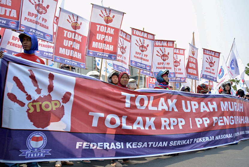 Para buruh yang tergabung dalam Federasi Kesatuan Serikat Pekerja Nasional (FKSPN) membawa poster sambil meneriakkan tuntutannya saat berunjuk rasa menuntut upah layak, di Semarang Jateng, Senin (26/10). (Antara/R. Rekotomo)