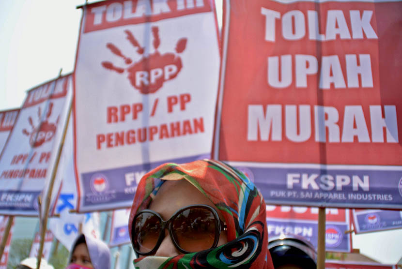 Para buruh yang tergabung dalam Federasi Kesatuan Serikat Pekerja Nasional (FKSPN) membawa poster sambil meneriakkan tuntutannya saat berunjuk rasa menuntut upah layak, di Semarang Jateng, Senin (26/10). (Antara/R. Rekotomo)