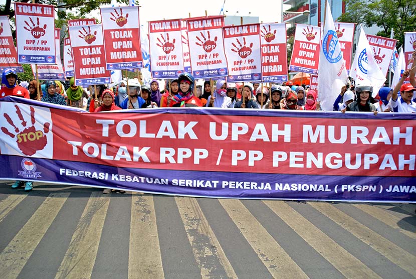 Para buruh yang tergabung dalam Federasi Kesatuan Serikat Pekerja Nasional (FKSPN) membawa poster sambil meneriakkan tuntutannya saat berunjuk rasa menuntut upah layak, di Semarang, Jateng. (Antara/R. Rekotomo)
