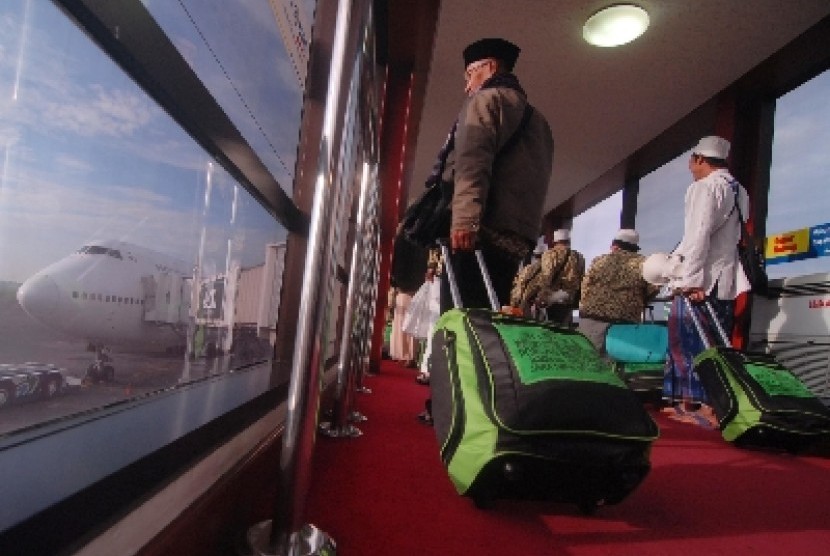 Para calon jamaah umrah berjalan menuju kabin pesawat akan mengantarkan mereka menuju Tanah Suci Makkah.