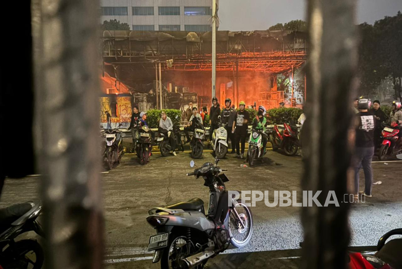 Para demonstran membakar pintu masuk Tol Dalam Kota di depan gedung DPR, Jumat (29/8/2025) malam..